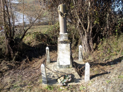 Cippo monumentale decorato, circondato da alberi e vegetazione, situato a Bergognoni.