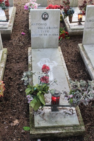 Tombe decorate con fiori e lumini, dedicate ai caduti per la Libertà in un luogo di commemorazione.