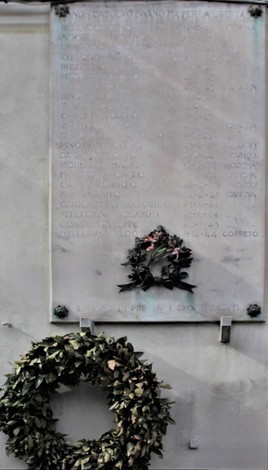 Lapide commemorativa dedicata ai caduti per la Libertà di Prè, accompagnata da una corona di fiori.