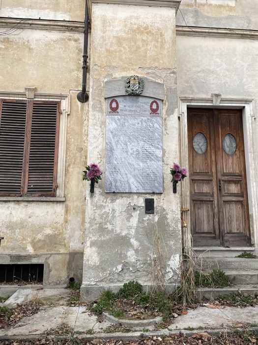 Lapide commemorativa dedicata alla Resistenza, situata a Collegno, su un muro di un edificio storico.