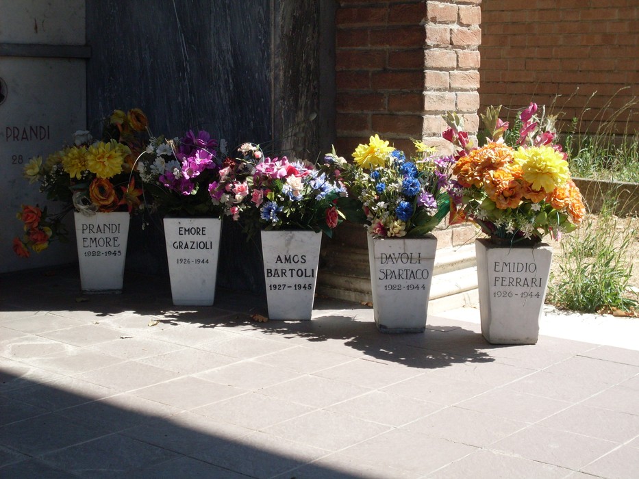 Fiori commemorativi al "Sacrario dei Caduti di Sesso", luogo di memoria e rispetto per i caduti.