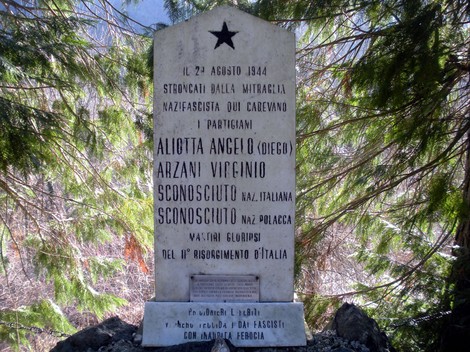 Monumento commemorativo ai partigiani Aliotta, Arzani, Busi e Mieczyslaw, situato in un'area montuosa.
