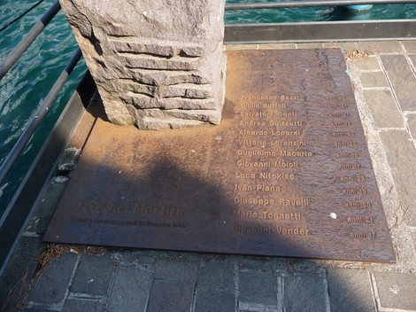 Monumento ai Tredici Martiri, commemorazione con nomi incisi su base metallica affacciata sull'acqua.