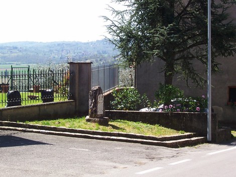 Cippo a Marmo e Marapitti in un paesaggio con cimitero e vegetazione, immerso nella tranquillità del territorio.