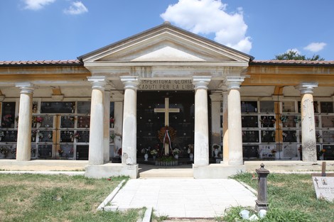 Sacrario ai caduti per la libertà, con una facciata maestosa e colonne, circondato da un verde curato.