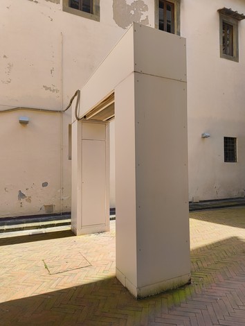 Struttura architettonica moderna in un cortile, con una superficie liscia e minimalista.