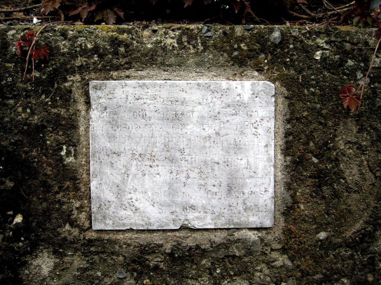 Lapide in commemorazione di Ferrotti, Foscale e Rodini, incastonata in un muro di pietra.