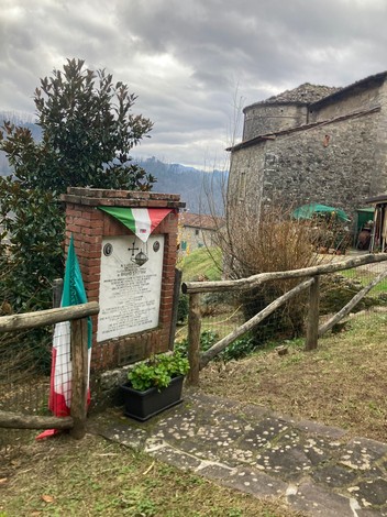 Monumento a Stefani con bandiere tricolori e cornice naturale, immerso nella storia.