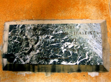 Lapide commemorativa di Macchieraldo, in marmo con decorazioni, situata in un contesto storico significativo.