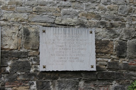 Lapide commemorativa dedicata agli ebrei deportati, incastonata in una parete di pietra.