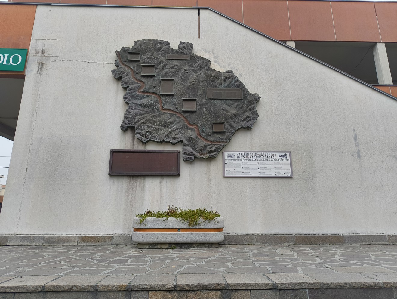 Monumento ai partigiani caduti di Pianoro, rappresentato da una scultura in rilievo su un muro.