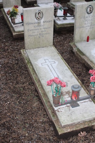 Tombe perpetue con fiori e candele, dedicate ai caduti per la Libertà, in un cimitero.