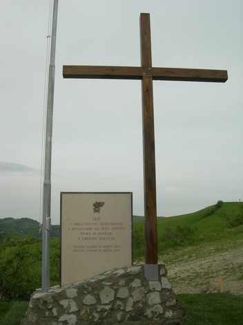 Monumento ai bersaglieri caduti, con una croce in legno e una stele commemorativa, immerso nella natura a Poggio Scanno.