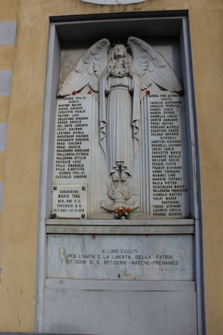Lapide commemorativa con angelo, dedicata ai caduti per la libertà a San Desiderio, decorata con fiori.