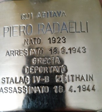 Pietra d'inciampo in ottone lucido incassata nella pavimentazione, con iscrizione dedicata a Piero Radaelli.