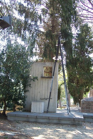 Monumento ai caduti, commemorazione in pietra circondata da alberi, simbolo di ricordo e rispetto per i defunti.