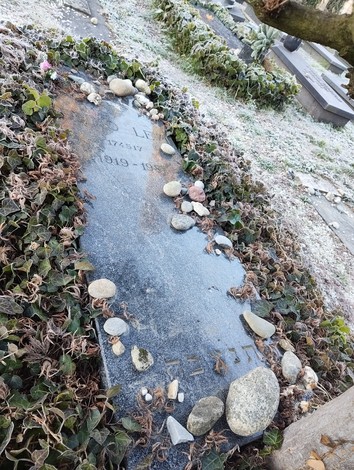 Sepolcro di Levi, con pietre e muschio, circondato da un'atmosfera silenziosa e rispettosa.