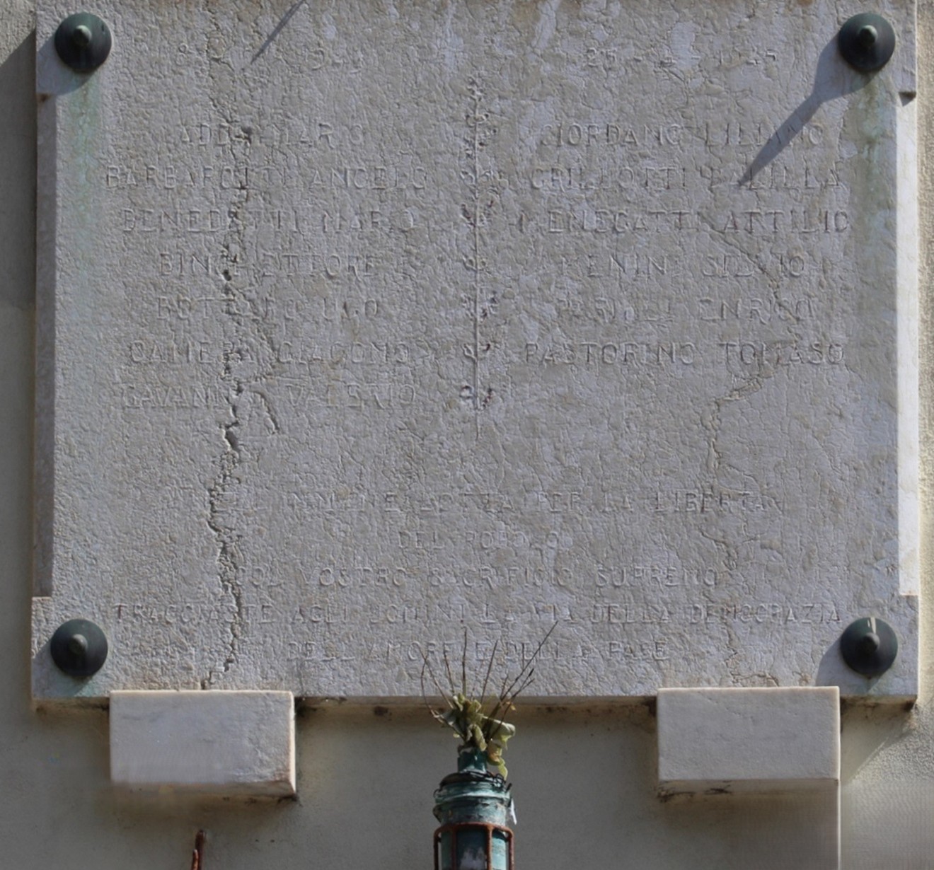 Lapide commemorativa dedicata ai caduti per la Libertà di Trasta, con dettagli in evidenza sulla parete.