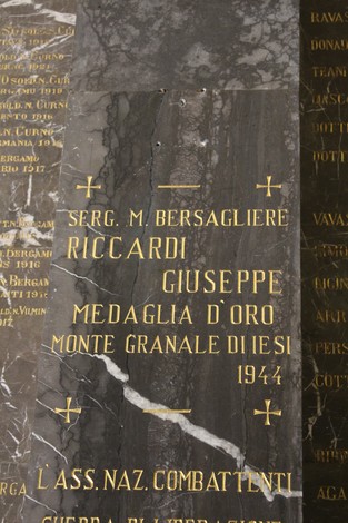Dettagli del Tempio dei Caduti con iscrizioni commemorative su un pannello di pietra.