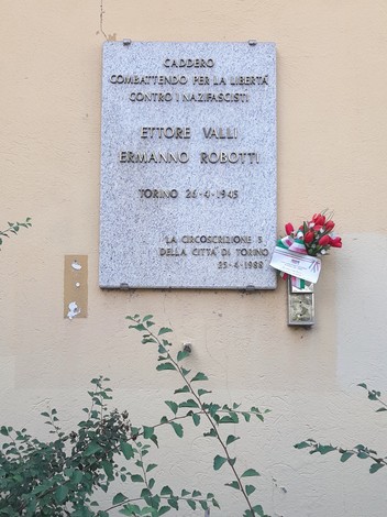 Lapide commemorativa in memoria di Ettore Valli ed Ermanno Robotti a Torino, con fiori freschi ai piedi.