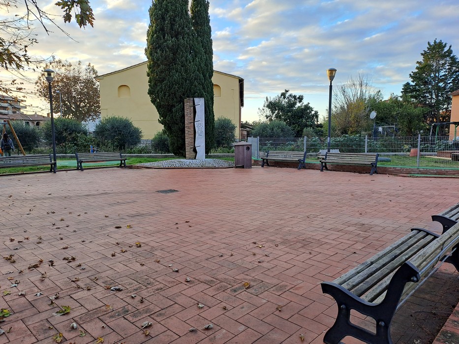 Monumento ai caduti per la Liberazione, situato in un'ampia area verde con panchine e alberi.