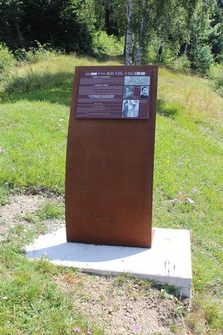Pannello informativo lungo la Strada della battaglia di Fonteno, immerso nella natura.