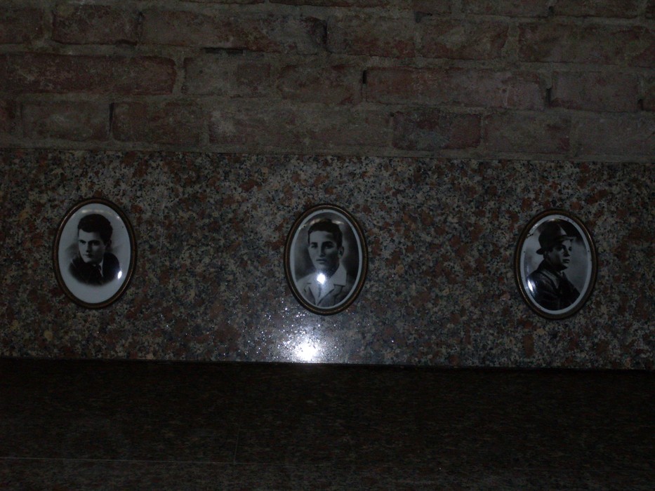Sacrario dei caduti di Luzzara con fotografie commemorative su una base in marmo.