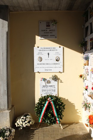 Lapidi commemorative al Cimitero di Cornalba, con fiori e decorazioni in omaggio ai defunti.