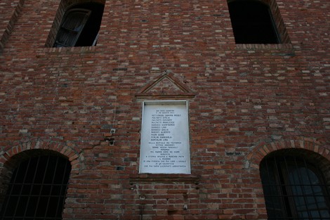 Lapide commemorativa della Tabaccaia di Prato Grande, collocata su un muro in mattoni.