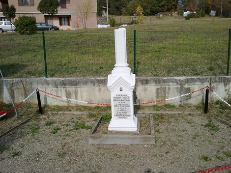 Monumento commemorativo "Cippo a Piccinini", collocato in un’area verde, circondato da una recinzione.