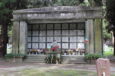 Sacrario dedicato ai caduti per la Liberazione, circondato da fiori e firme commemorative.