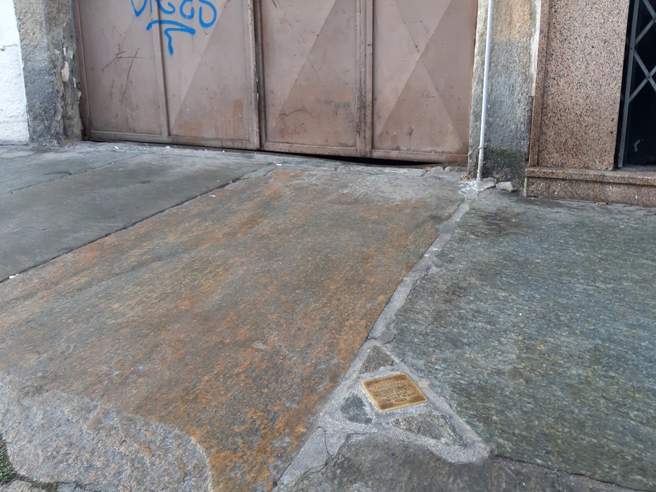 Pietra d'inciampo dedicata a Vittorio Staccione, situata su un marciapiede accanto a un cancello.