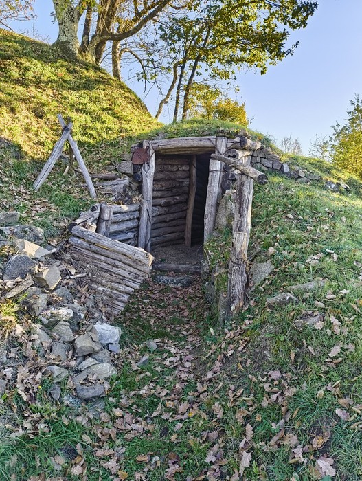 Entrata di un rifugio nella natura, simbolo di memoria della guerra e della resistenza storica.