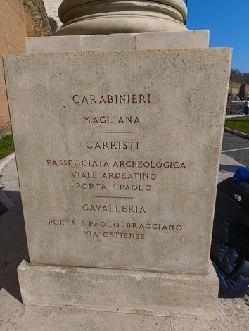 Cippo commemorativo ai caduti, dedicato alla difesa di Roma, con iscrizioni storiche.
