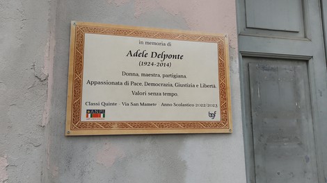 Targa commemorativa dedicata a Adele Delponte, maestra e partigiana, con valori di pace e giustizia.