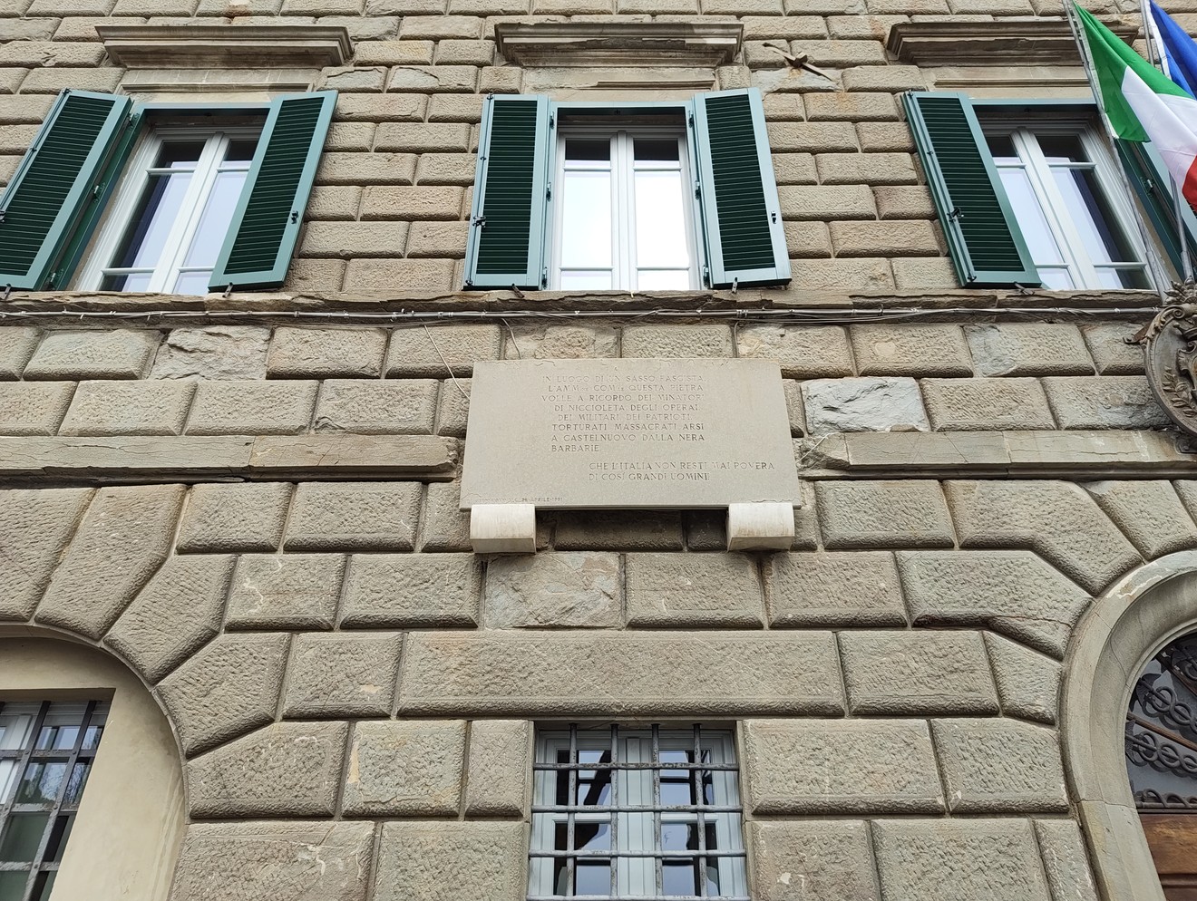 Lapide commemorativa dedicata ai minatori di Niccioleta e ai caduti per la libertà, posizionata su un edificio.