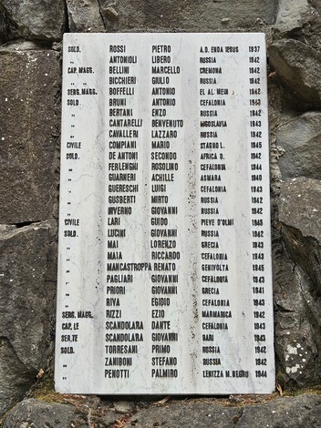 Monumento commemorativo ai caduti di Stagno Lombardo, con iscrizioni di nomi su una parete di pietra.