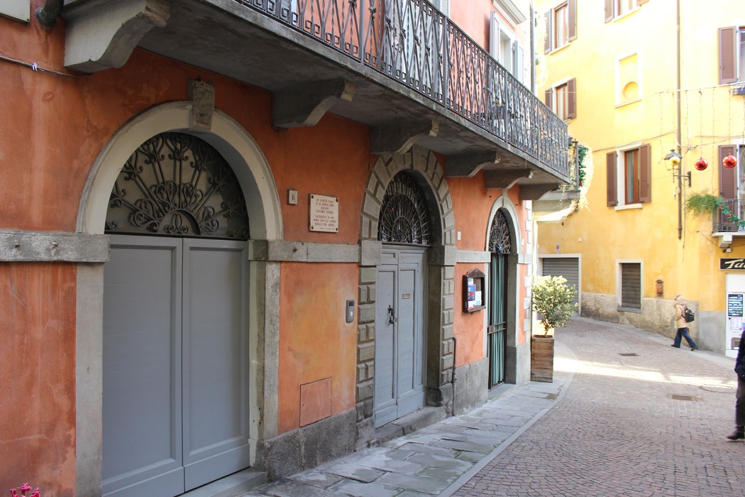 Vista di un vicolo caratteristico con edifici colorati e dettagli architettonici, tra cui una lapide a Vender.