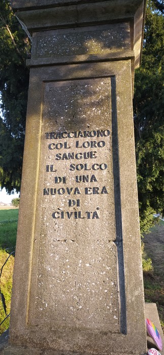 Monumento ai caduti dell'Amola, con iscrizioni commemorative su una colonna di pietra.