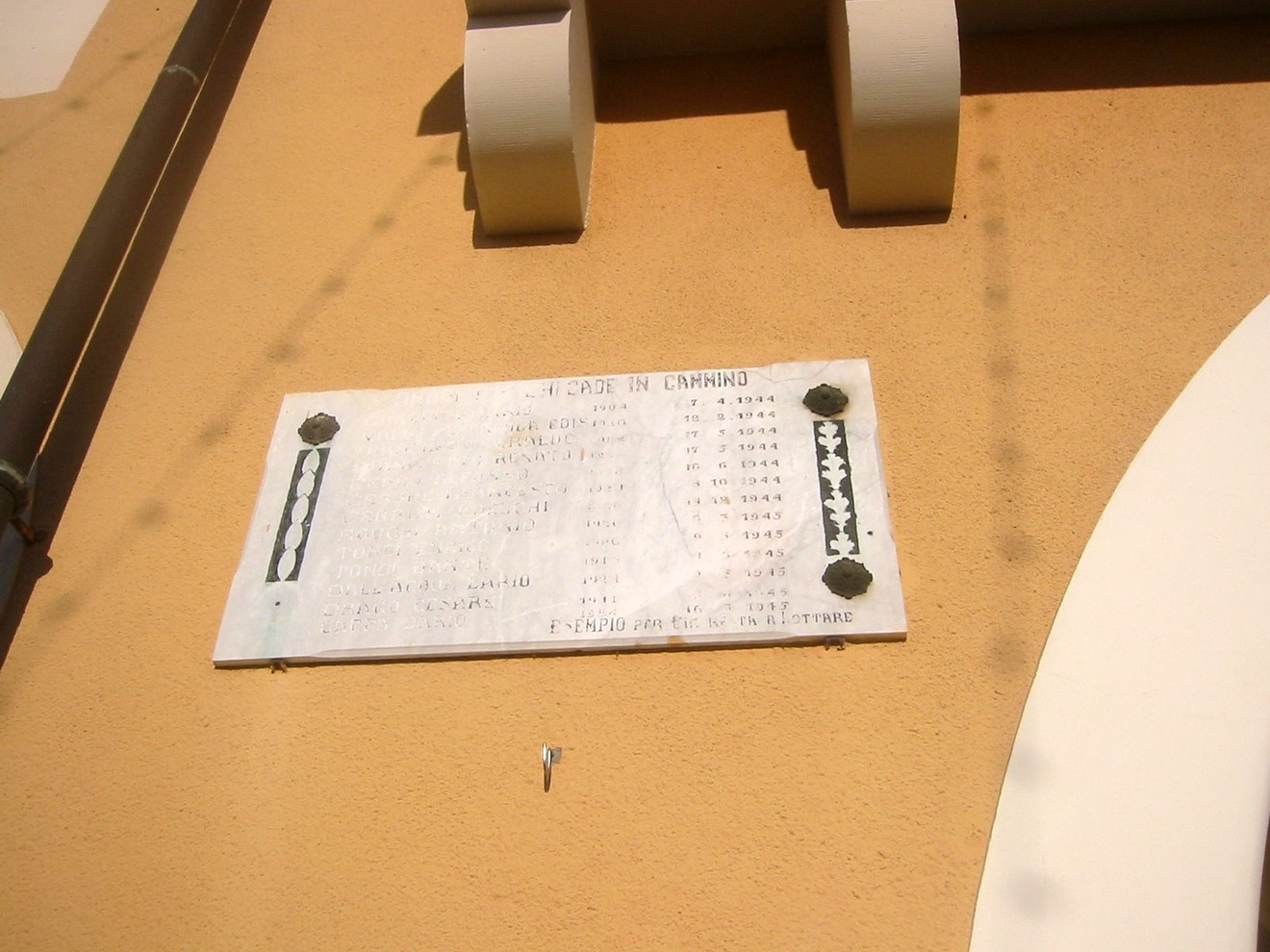 Lapide commemorativa in onore dei caduti della Resistenza, ubicata su una parete esterna.