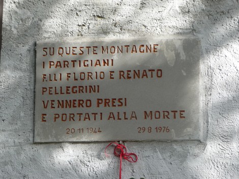 Lapide commemorativa dedicata ai fratelli Pellegrini, partigiani, situata su una montagna.