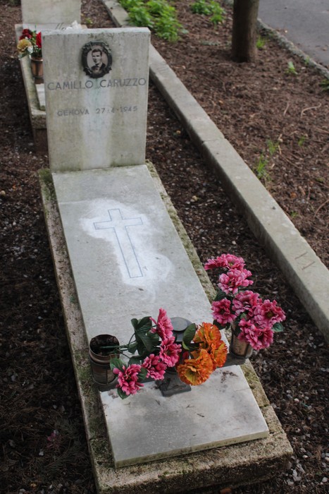 Tomba con fiori commemorativi, dedicata a un caduto per la libertà in un cimitero.