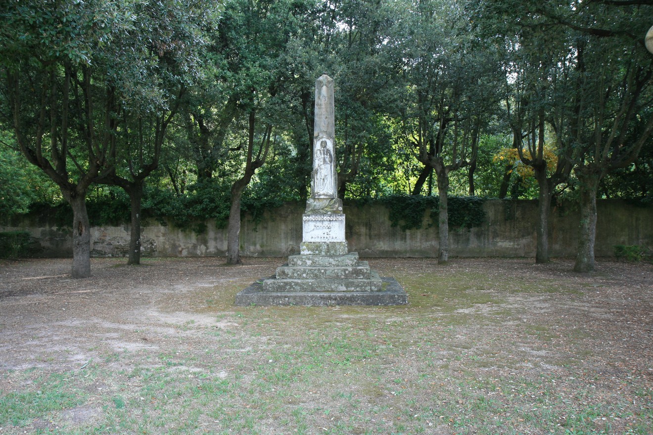 Obelisco ai caduti di Molina, circondato da alberi in un'area verde tranquilla.