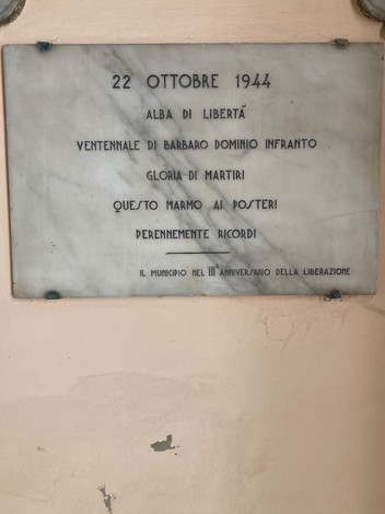 Lapide commemorativa che celebra la liberazione di Cervia, con dettagli storici e onori ai martiri.