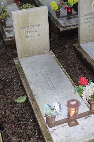 Tombe perpetue dedicate ai caduti per la Libertà, con decorazioni floreali e candele accese.