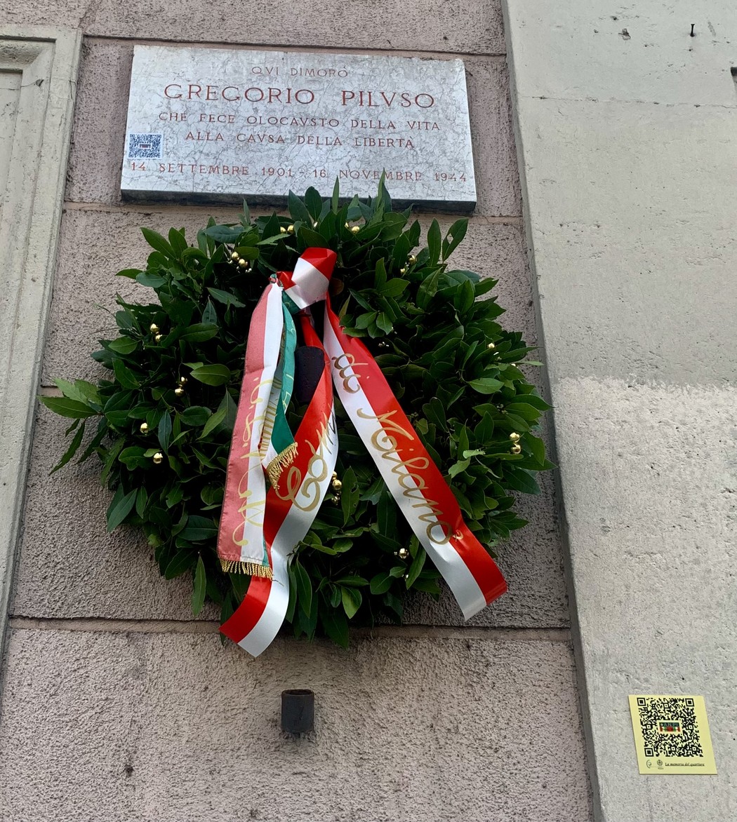 Lapide commemorativa a Gregorio Piluso, con corona di alloro e nastri tricolori in onore della libertà.