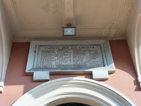 Lapide commemorativa dedicata ai caduti per la Libertà, posta in un contesto architettonico significativo.