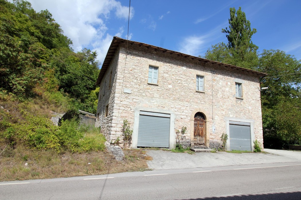 Lapide commemorativa dedicata a Agostini e Morganti, situata su un edificio storico in un contesto naturale.