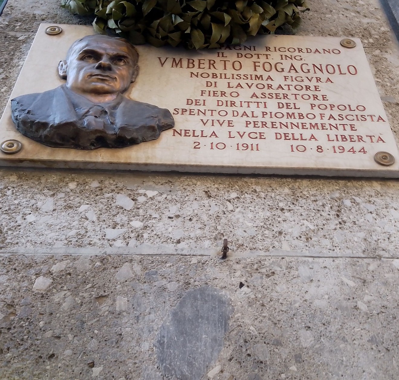 Lapide commemorativa dedicata a Umberto Fogagnolo, con un ritratto e una corona di alloro.