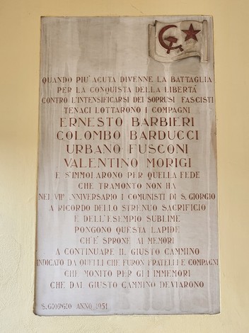 Lapide commemorativa dedicata ai caduti di San Giorgio, con nomi di eroi e messaggi di memoria.
